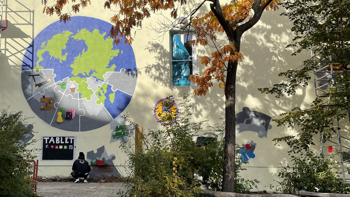 Haus der KreativFabrik von vorne, darauf eine Weltkugel