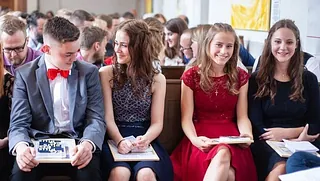 Konfirmanden im Konfirmationsgottesdienst, auf Kirchenbank sitzend