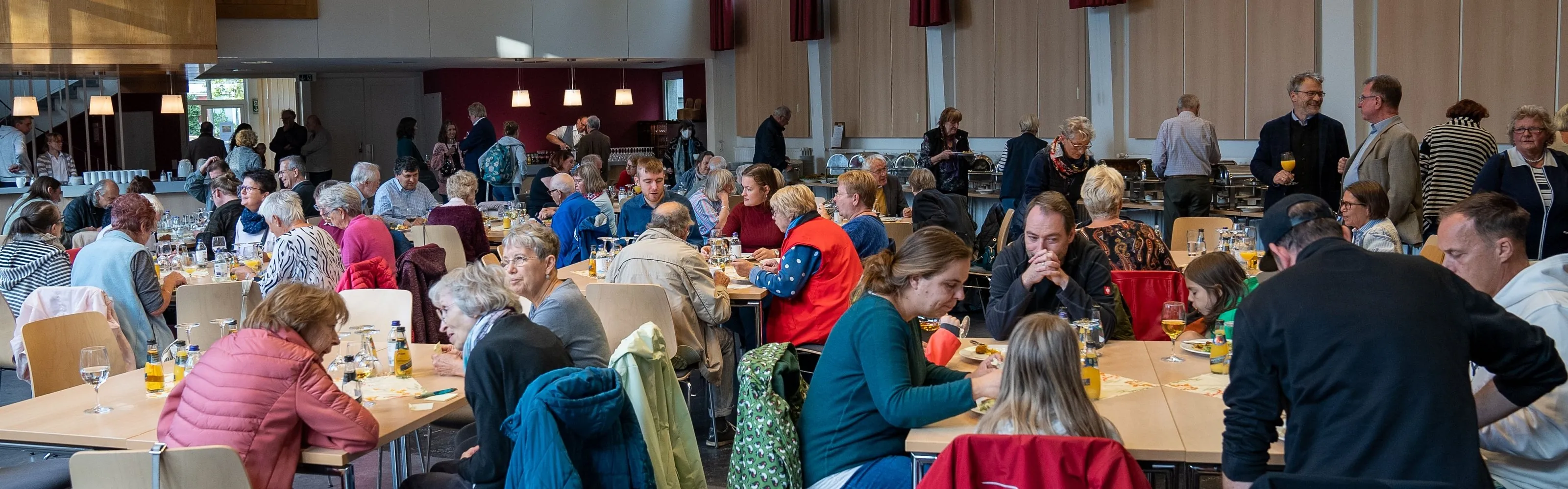 Viele Menschen sitzen an Tischen im Hermann-Ehlers-Haus und feiern