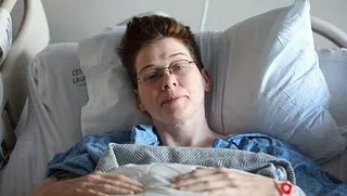 Frau im Krankhausbett liegend